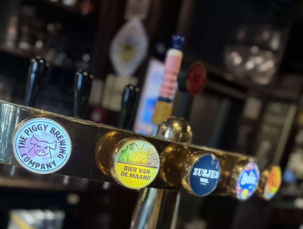 Tapkraan met bierlogo's aan de bar van Zusjes de Boer