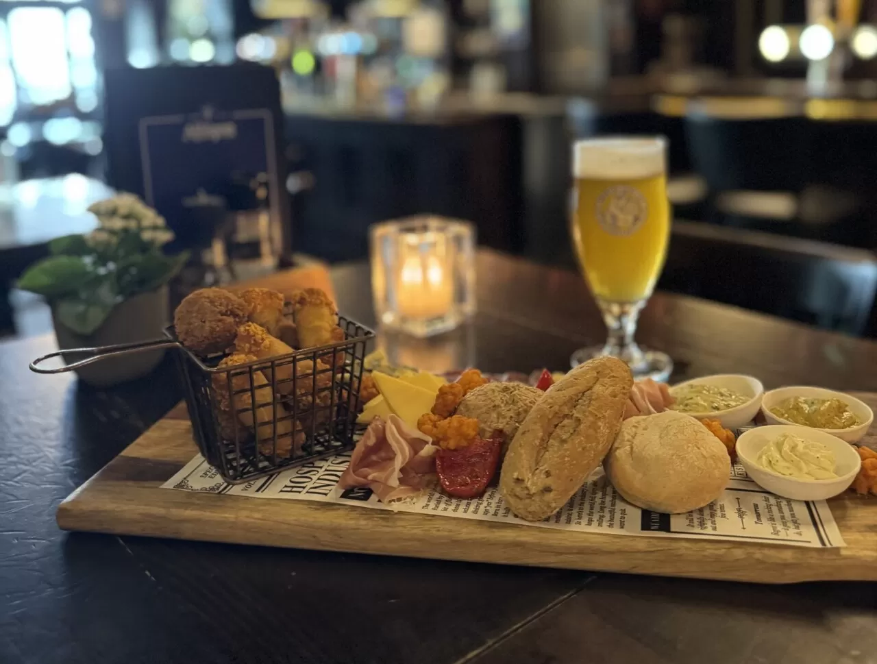 Borrelplank met een glas speciaalbier op een tafel in eetcafé Zusjes de Boer
