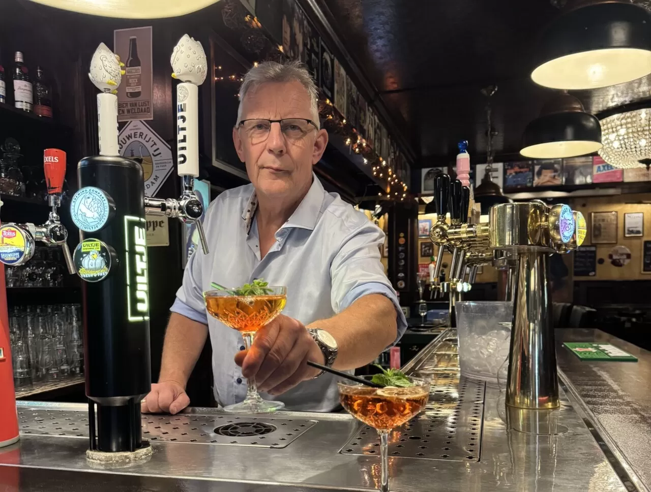 Een van de eigenaren van Zusjes de Boer serveert twee cocktails aan de bar