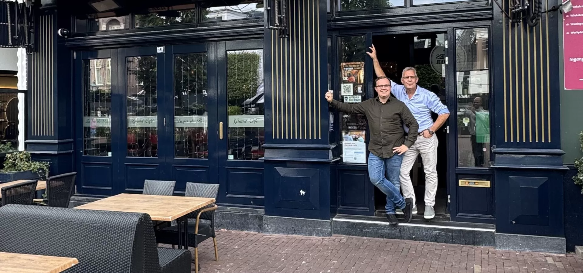 De gevel en entree van Zusjes de Boer aan de Markt met de eigenaren in de deuropening