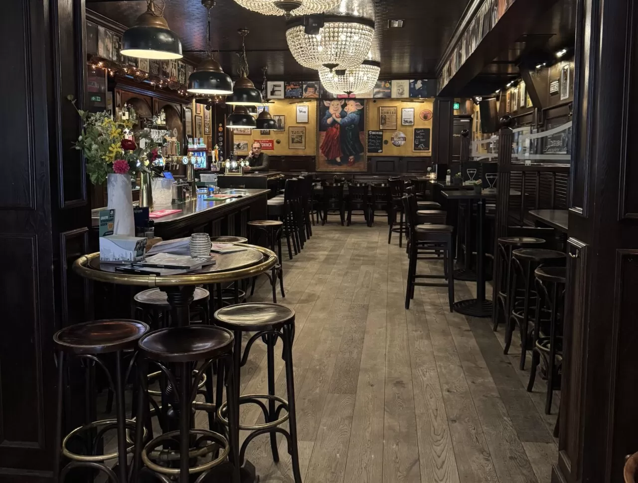 De lange zaal van eetcafé Zusjes de Boer met kroonluchters en statafels