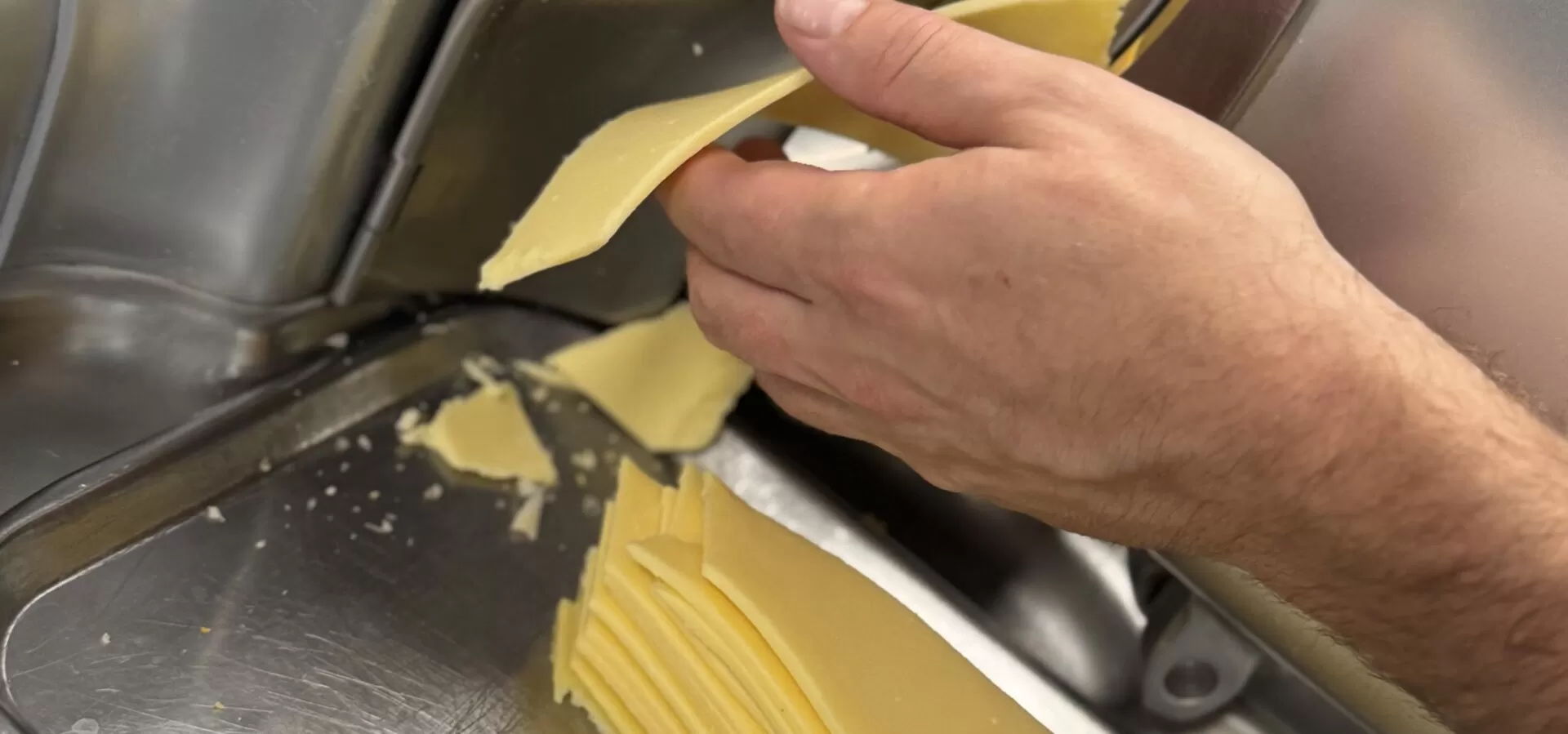 Kaas wordt vers gesneden in de keuken van Zusjes de Boer
