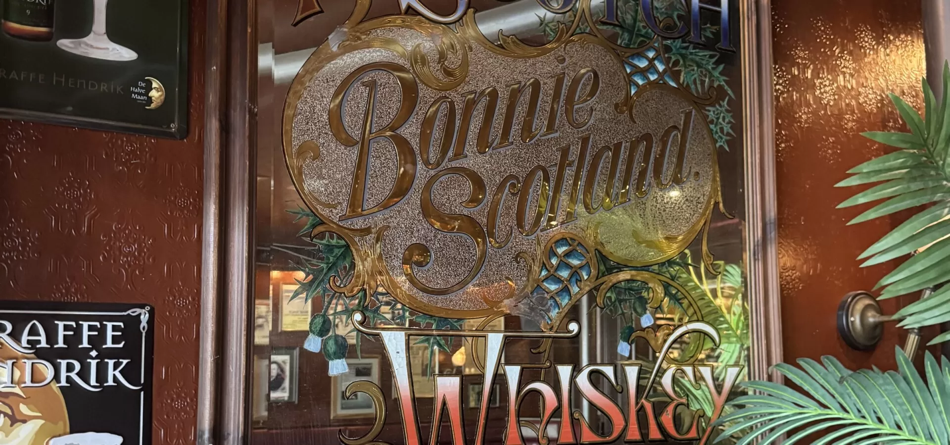 Oude bierreclame en spiegel aan de muur van Zusjes de Boer