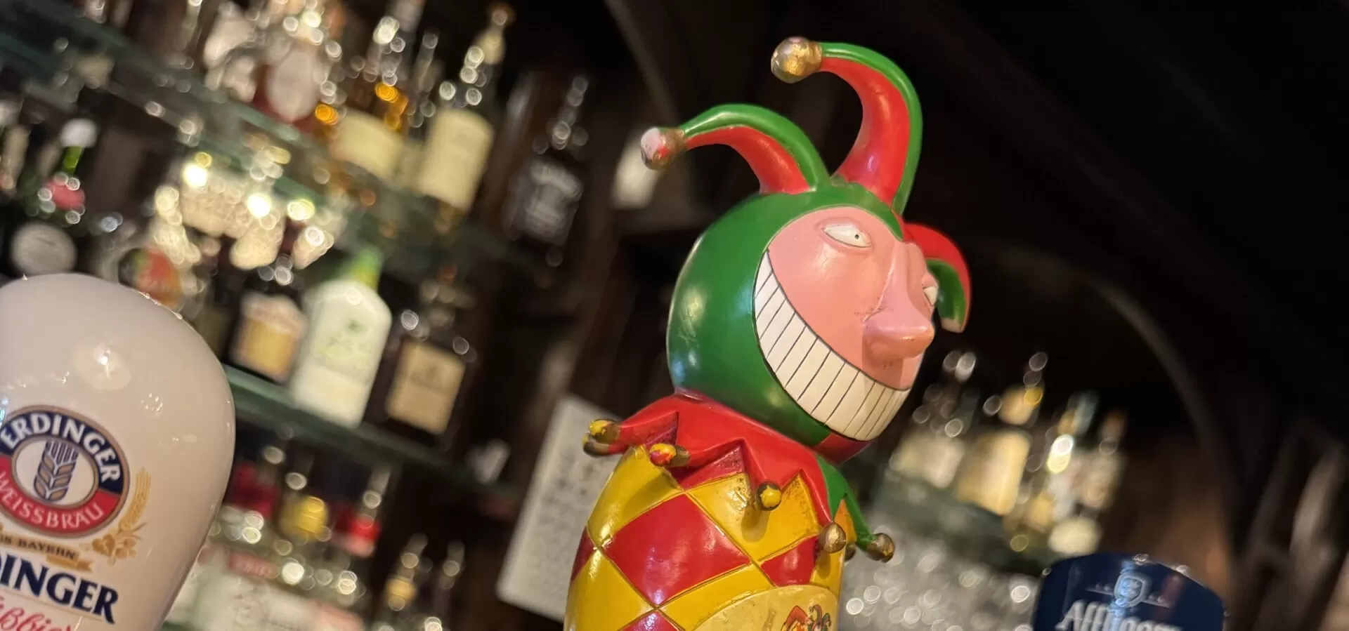Kleurrijke tapkraan in de vorm van een nar aan de bar van Zusjes de Boer