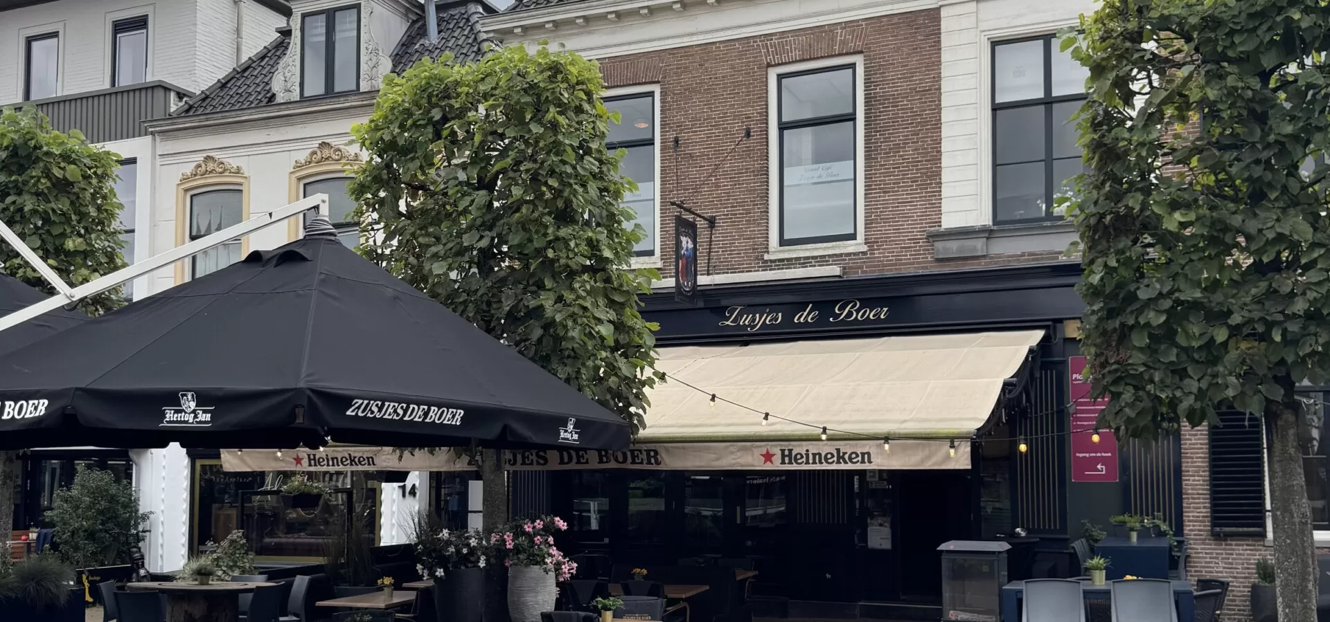 Het terras van Zusjes de Boer aan de Markt in Assen onder een wolkenlucht
