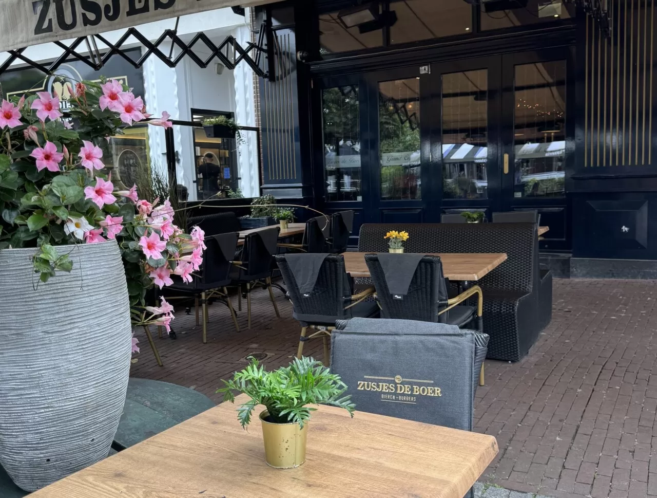 Een tafeltje op het terras van Zusjes de Boer met bloemen aan de Markt