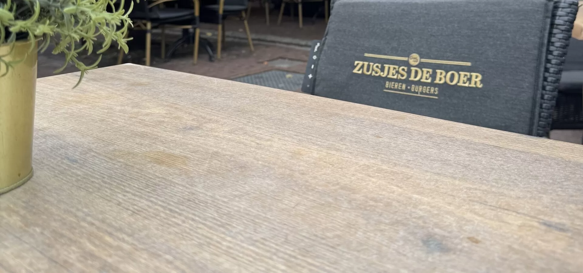 Terrastafel met zitkussen met het logo van Zusjes de Boer