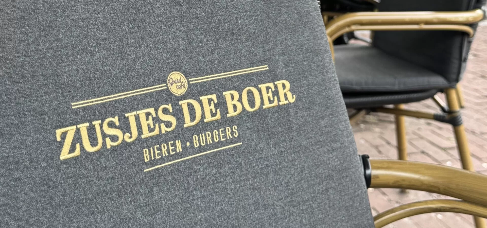 Zitkussen met het logo van Zusjes de Boer op het terras